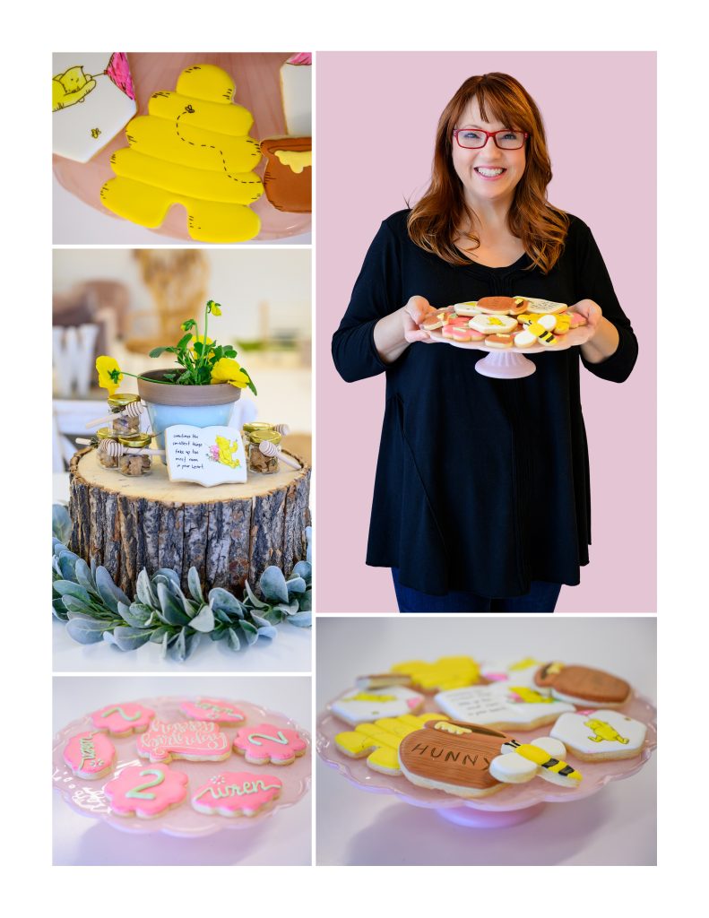 A woman smiling and holding a plate of themed cookies shaped like honey pots, bees, and a honeycomb.