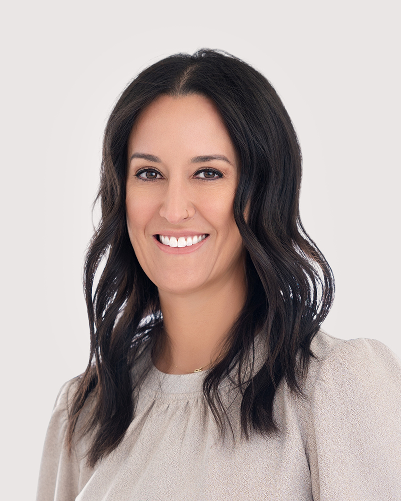 Professional headshot of Dr. Rachel McKinzie, owner and medical director at Mac Aesthetics in Edmond, OK, wearing a neutral top and smiling confidently.