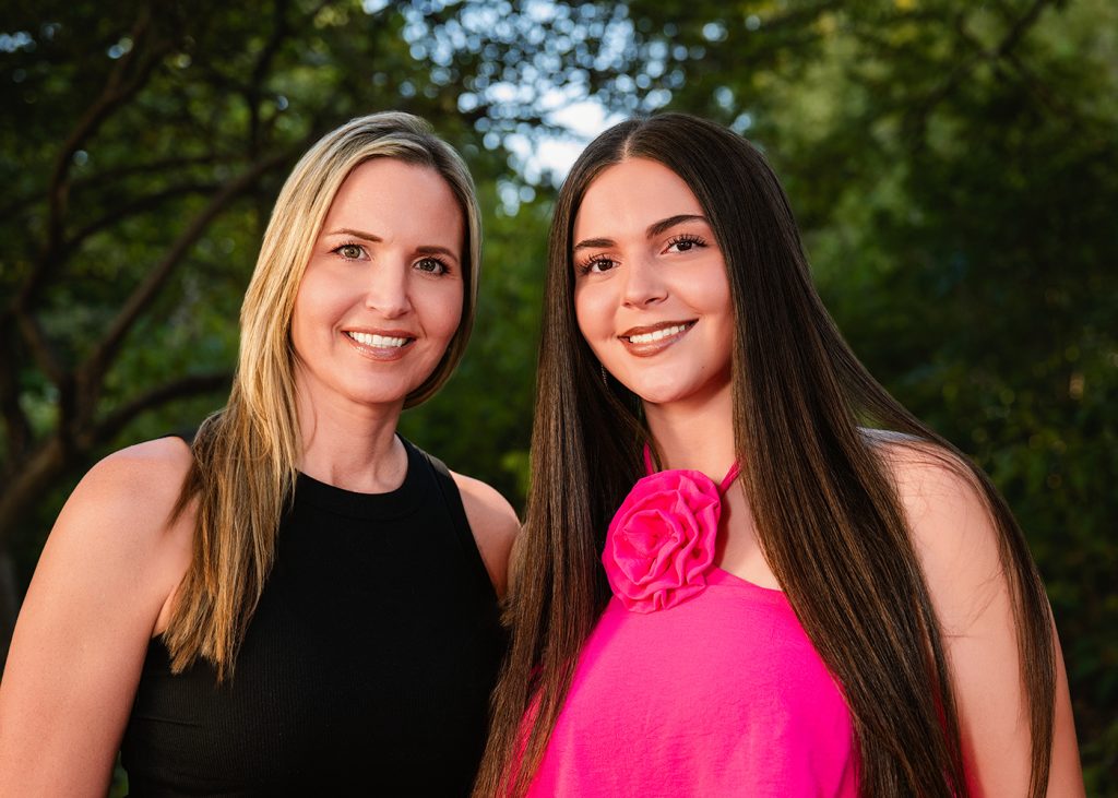 Mom and daughter during Peyton's senior photo session at the Myriad Gardens in OKC. One wears a black top, the other a pink top with a large flower detail.
