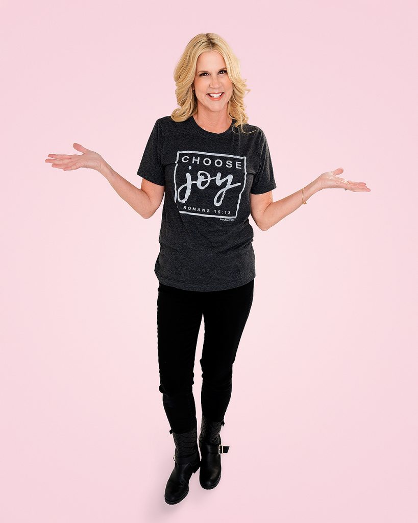 A woman wearing a t - shirt with the words choose joy on it