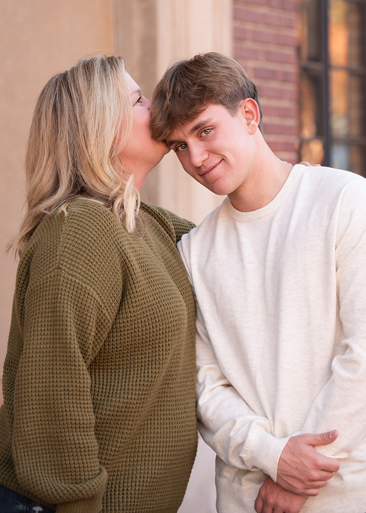 A candid moment of a mom and son cxaptured by senior photographer, J. Hill Photography.