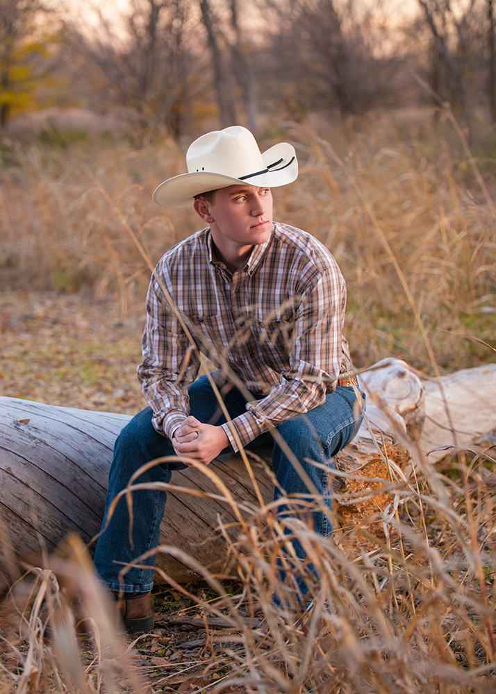 William poses on a log for his senior photos in Oklahoma City.
