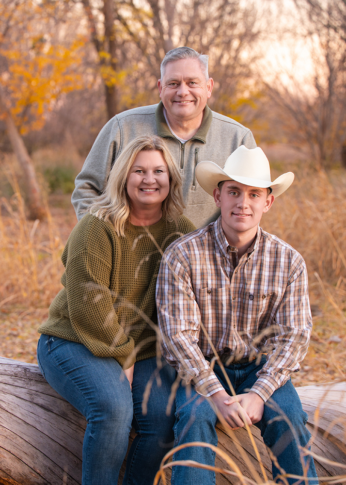Senior guy with his parents during his senior portrait session.