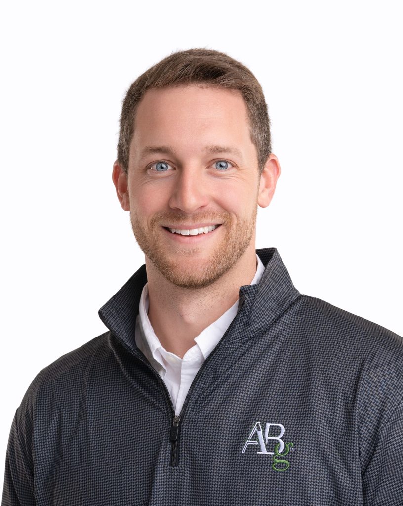 Corporate headshot of a man wearing a company logo quarter-zip at Rose + Salt Studio by J. Hill Photography