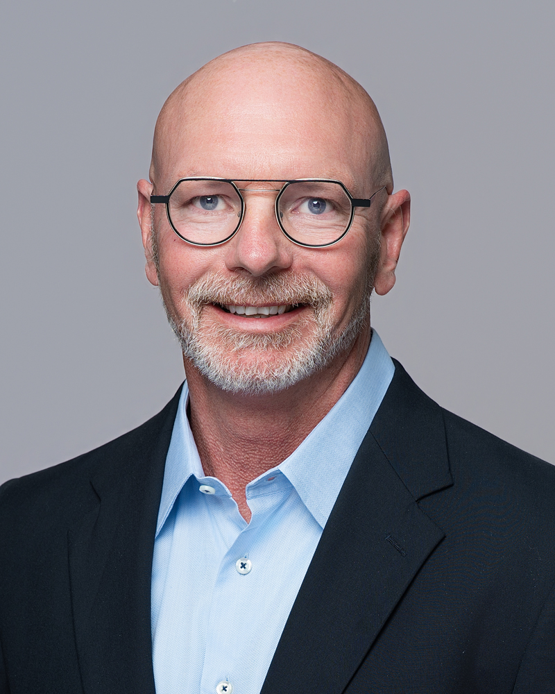 Professional headshot photographed inside a modern Oklahoma City office