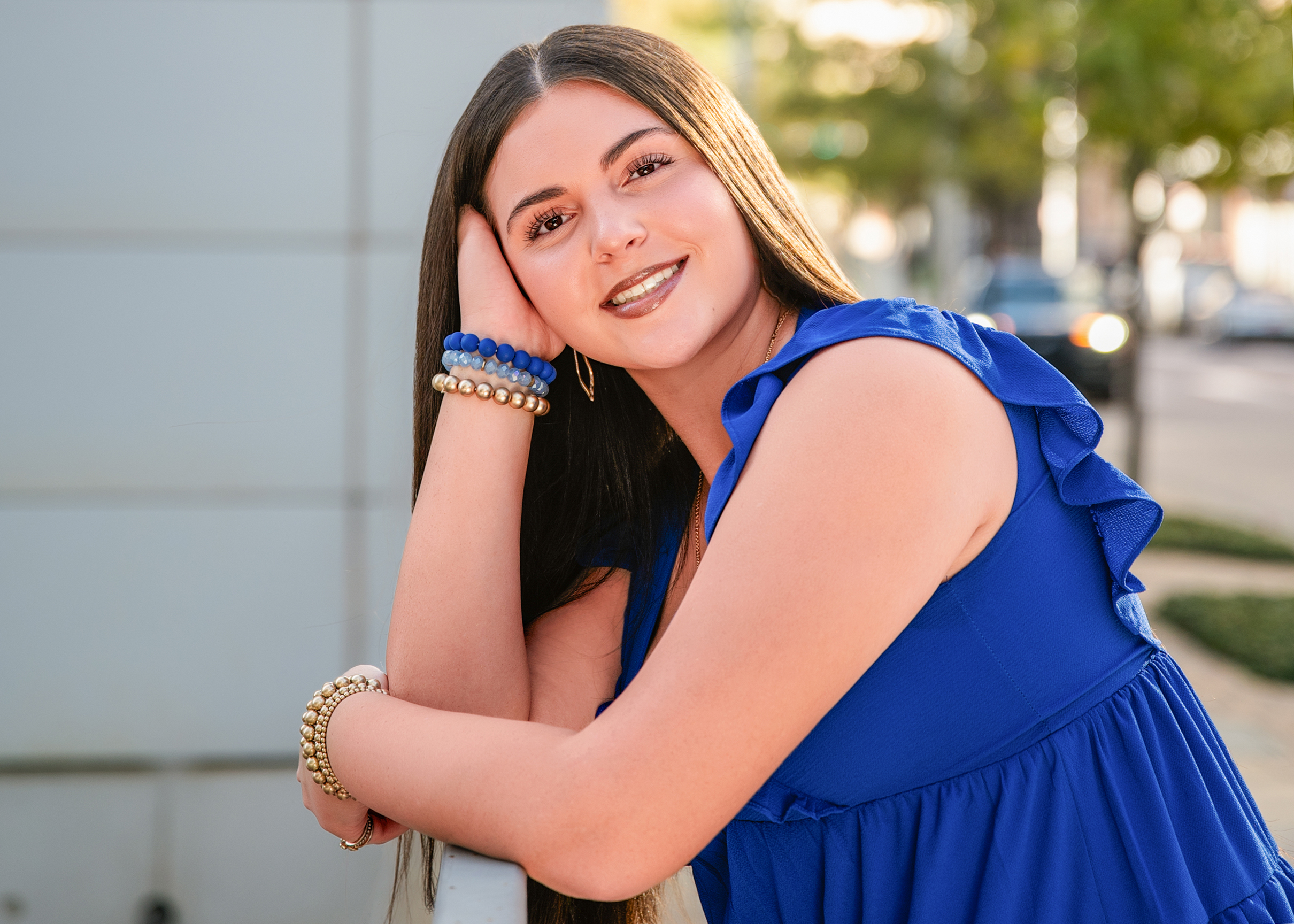 High school senior girl in blue dress posing outdoors in urban setting during Oklahoma City senior portrait session