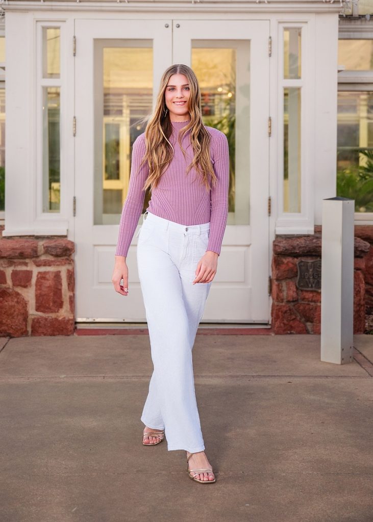High school senior girl walking outdoors in Oklahoma City during senior portrait session with natural posing